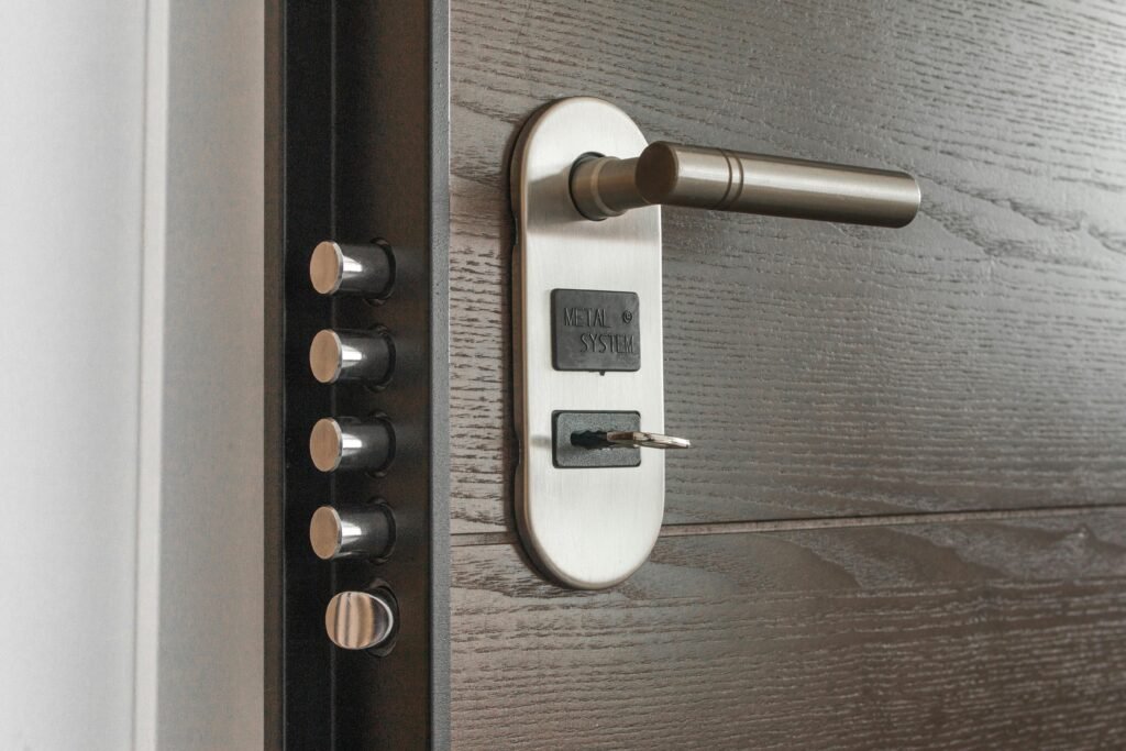 Cylindre de serrure : Comment mesurer et remplacer son barillet ? Metal door handle and lock system with key inserted, showcasing security features.